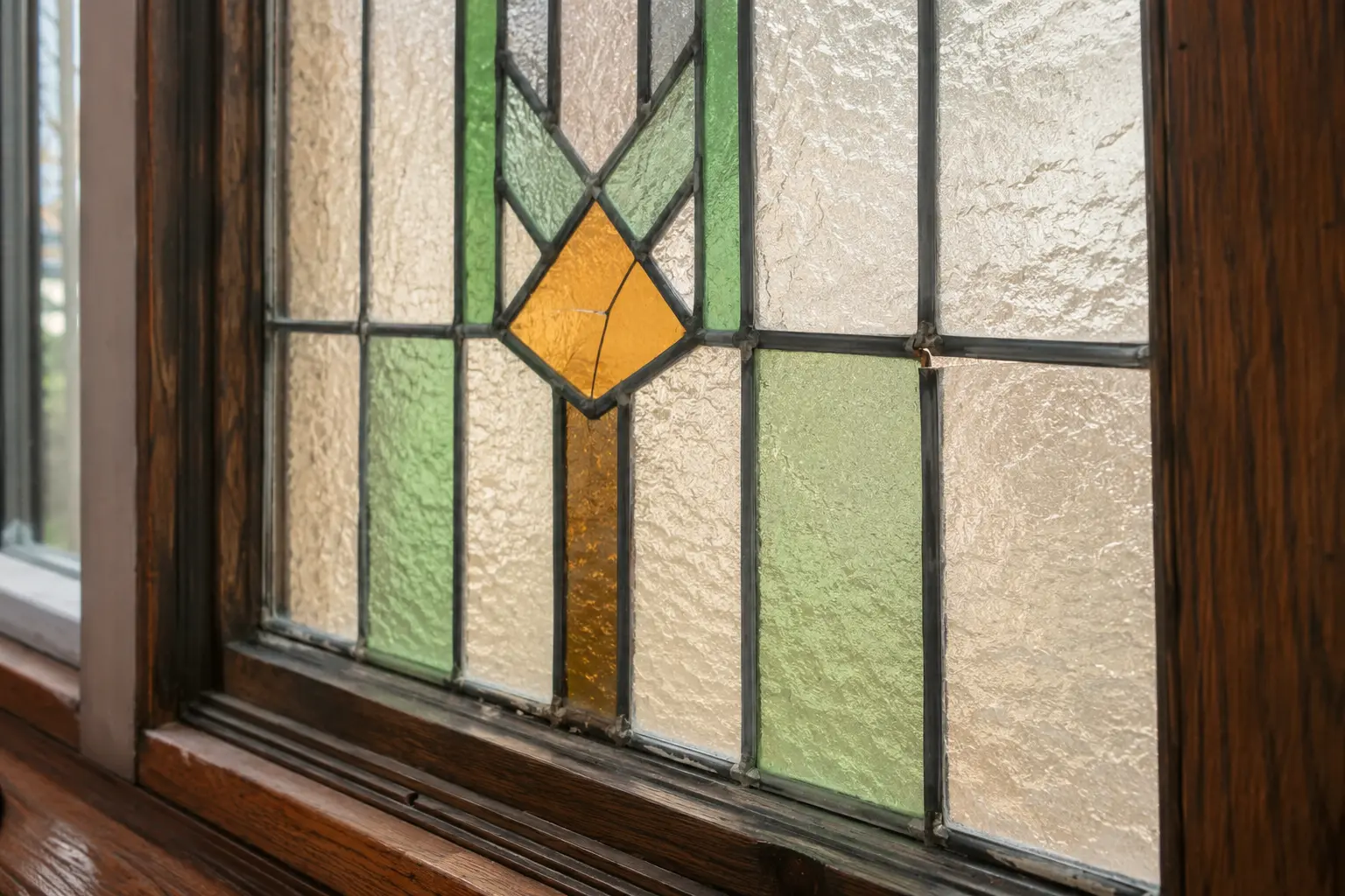 Cracked amber piece and separated solder joint in an older leaded stained glass window